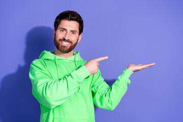 Naklejka premium Photo of mature age funky man wearing bright green hoodie sportswear holding hand black friday discount isolated on violet color background