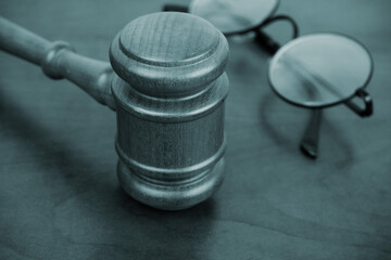 Judge gavel and round eyeglasses on table close-up. Laws and legal proceeding concept.