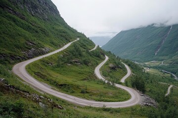 Fototapeta premium Winding Mountain Road Through Lush Green Hills in Norway on a Cloudy Day With Misty Peaks