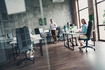 Full length photo of teamwork startup partners people coworking modern comfortable nice creative startup office loft room interior