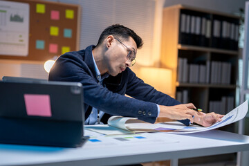 Stressed asian businessman working late and having neck pain