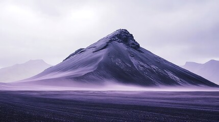 Fototapeta premium A lone mountain peak rises up from a flat, barren landscape in a soft, purple hue.