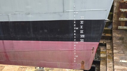 A draft mark or plimsoll line on the hull of a ship. These markings indicate how deeply a ship sits...
