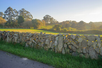 Finca rural tras límite de muro antiguo de piedras en Asturias