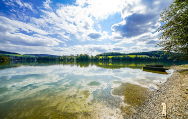 View of the shore of Lake Diemelsee and the surrounding landscape. Idyllic nature by the lake in...