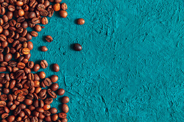 Coffee beans on turquoise background. Copy space.