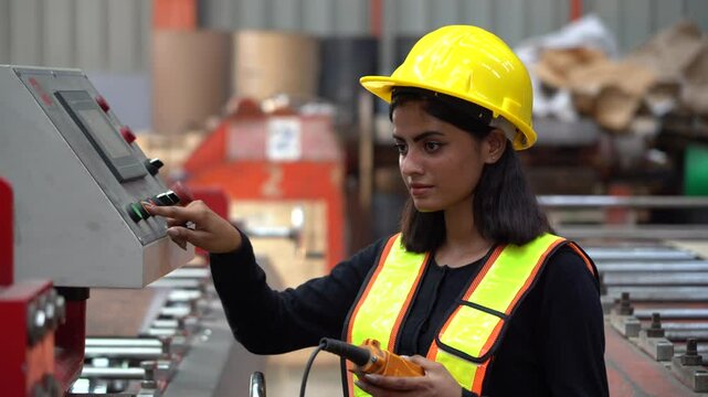 Indian engineer woman control machinery in industrial manufacturing factory. India worker female