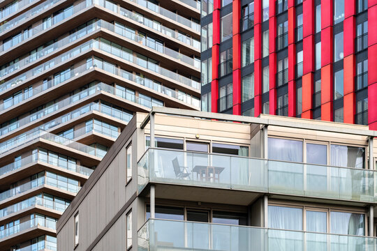 Contemporary high-rise residential buildings with a mix of reflective glass facades and contrasting colored panels, under natural daylight in Rotterdam - Powered by Adobe