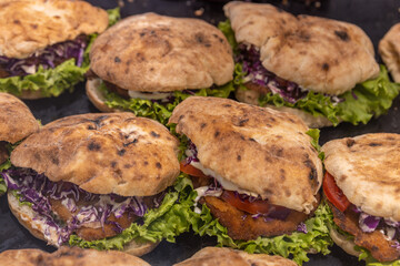 Row of sandwiches with lettuce and tomato on them