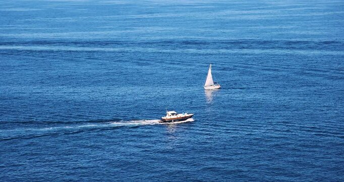 Incrocio di barca a motore e barca a vela sul mare calmo 