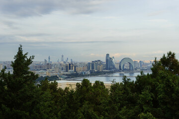 view of the city from above with modern architecture and old reflected in water of caspian sea baku city bay