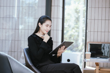 Happy and smiling Asian businesswoman with smartphone with success concept at work