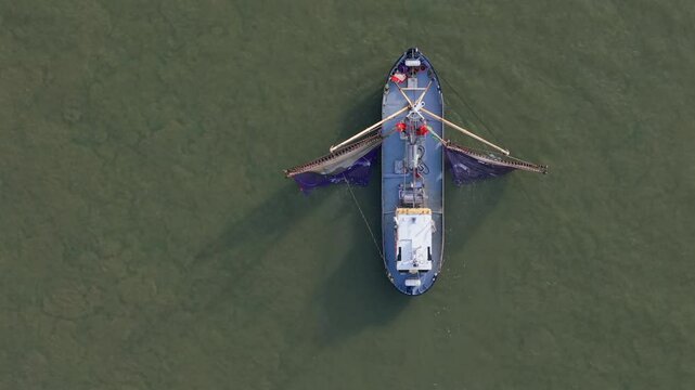 Aerial top down of fishing ship, boat trawling nets at Wadden sea