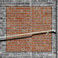 Cornice bianco e nero con foto a colori di corrimano su muro a mattoni rossi.