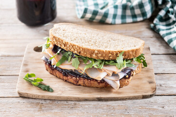 Turkey sandwich with cranberry sauce for Thanksgiving on wooden table