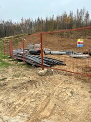 construction, building materials stacked behind a fence, stacked tubes
