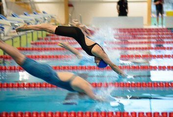 Women swimmers start from the starting table in the pool
