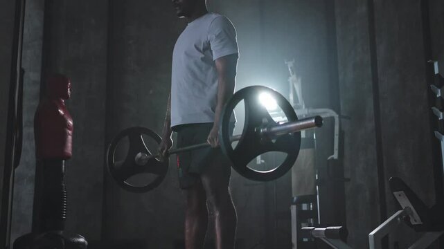 Fitness workout healthy lifestyle. African American man bodybuilder weightlifter picking up barbell doing heavy deadlifts in gym Weightlifting workout weight training muscles Man doing sports exercise