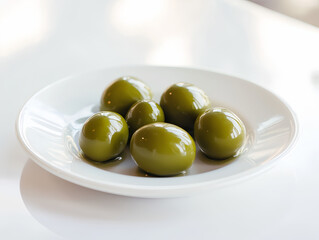 fresh green olives on a white plate with natural lighting