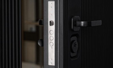 Ajar modern black armored entrance door to the apartment. Privacy, protection of the apartment and...