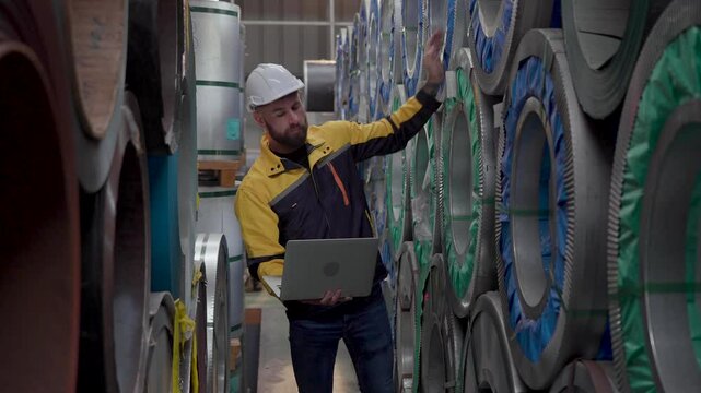 engineer manager storehouse using laptop computer inspecting or checking inventory products stock in warehouse factory