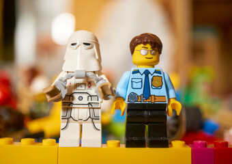 Fototapeta premium Lego brand Star Wars Snowtrooper and a police officer toy figurines on a blurred background
