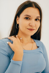 Obraz premium A woman in a white shirt and jeans showing a stylish and understated look. The light background and natural pose give the shot a modern feel.
