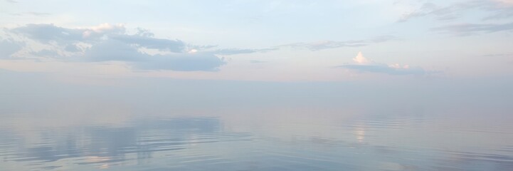 Fototapeta premium Serene vertical shot of still water reflecting the sky, aquatic, vertical