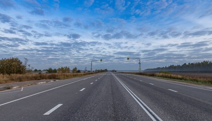 Long, empty road with a few trees in the background