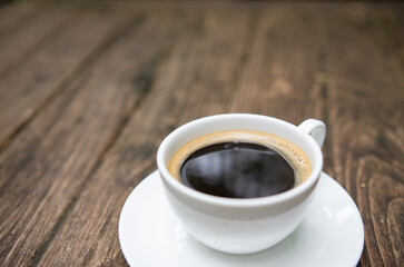 Cup of aromatic coffee on wooden table. Space for text