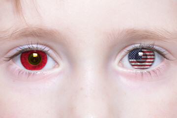 human face with national flags of kyrgyzstan and united states of america in the eyes.