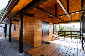 Fototapeta premium This charming wooden house features a welcoming porch for relaxation, a sturdy roof for protection, making it an ideal cozy dwelling for anyone seeking a peaceful home environment