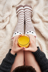 Woman on bed with bear socks and orange juice
