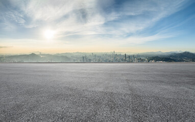Empty asphalt road space and distant mountains with city skyline