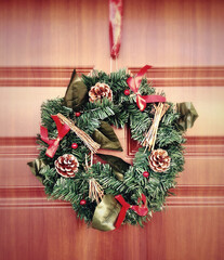 Christmas wreath hanging on a wooden door, celebrating the festive season