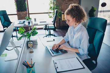 Young businesswoman working on a laptop at a modern office workstation