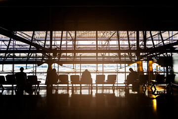 Waiting in the airport, backlit perspective, silhouettes of people waiting for travel at the...