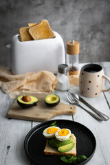 
Sandwiches with avocado, tomatoes and poached eggs. on a wooden backyard. Snidanok.
