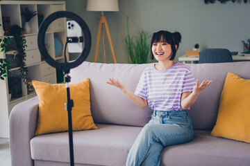 Photo of adorable sweet lady wear violet striped t-shirt recording video modern device indoors room...