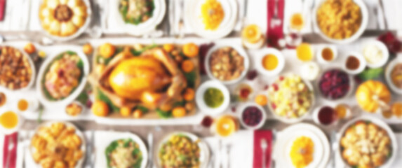 Blurred background of a table set for a celebration, with a centerpiece of fresh flowers and a mouthwatering spread of Thanksgiving dishes, background, thanksgiving day