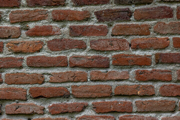 Antique clay brick wall with gray cement lines. Concept: Bricks, wall, vintage, background, industrial.