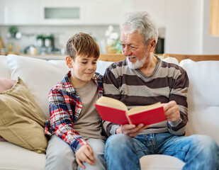 grandchild family child book reading elderly grandfather grandson boy together read learning education grandparent story fun leisure teaching storytelling senior