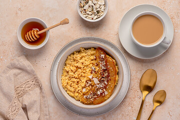 Food photography of millet porridge with caramelized banana, pecan, nuts, coconut flakes, chia, flaxseeds, honey, tea with almond milk