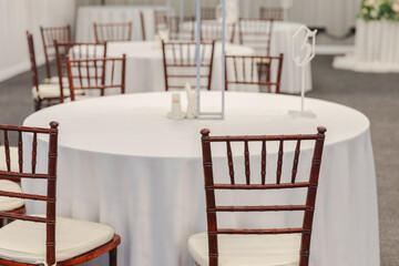 Decorated interior for festive event. Fancy table set for dinner in restaurant, luxury interior background. Wedding elegant banquet decoration arranged by catering service
