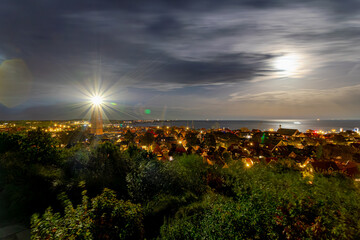 The Vuurtoren Brandaris Lighthouse with illuminated of full moon and stars at night time, The Dutch Wadden Sea, A municipality and an island in the northern, Friesland, West-Terschelling, Netherlands.