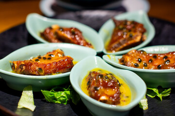 several small bowls of food including meat, cheese, and vegetables.