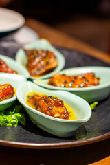 several small bowls of food including meat, cheese, and vegetables.