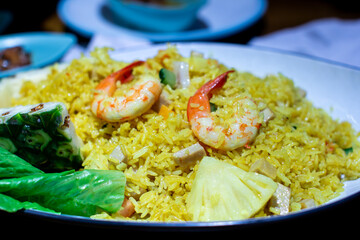 a pan of rice with shrimp and rice with a salad in the background