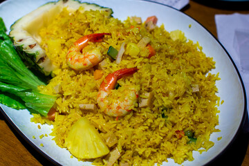 a pan of rice with shrimp and rice with a salad in the background