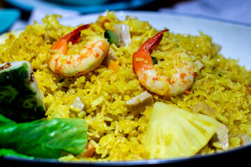 a pan of rice with shrimp and rice with a salad in the background